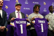 Vikings coach Kevin O'Connell and General Manager Kwesi Adofo-Mensah flank the team's first-round draft picks, J.J. McCarthy and Dallas Turner, on Fri