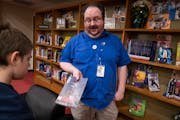 Library media specialist Ted Anderson helped eighth-grader Milton Norcross find a book in the school library at Franklin STEAM Middle School in Minnea