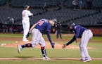 Minnesota Twins' Gary Sanchez, bottom left, is congratulated by third base coach Tommy Watkins after hitting a home run off of Oakland Athletics pitch