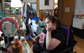 Raven Moe, who was born with spina bifida, gets ready to attend a rally against funding cuts for disability services in May at her home in Richfield.