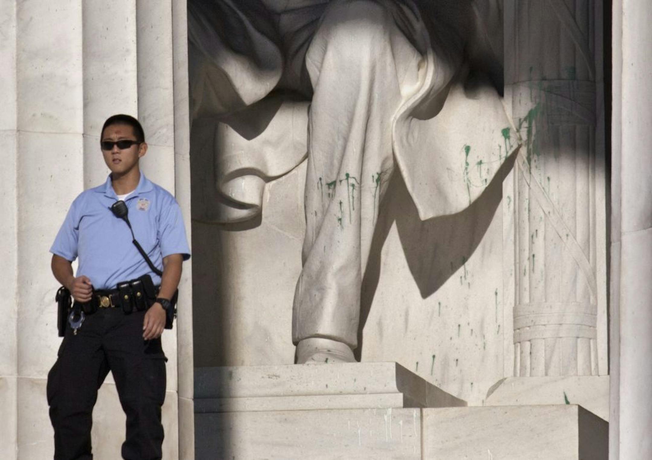 A U.S. Park Police officer stands guard next to the statue of Abraham Lincoln at the memorial in Washington, Friday, July 26, 2013, after the memorial was closed to visitors after someone splattered green paint on the statue and the floor area.