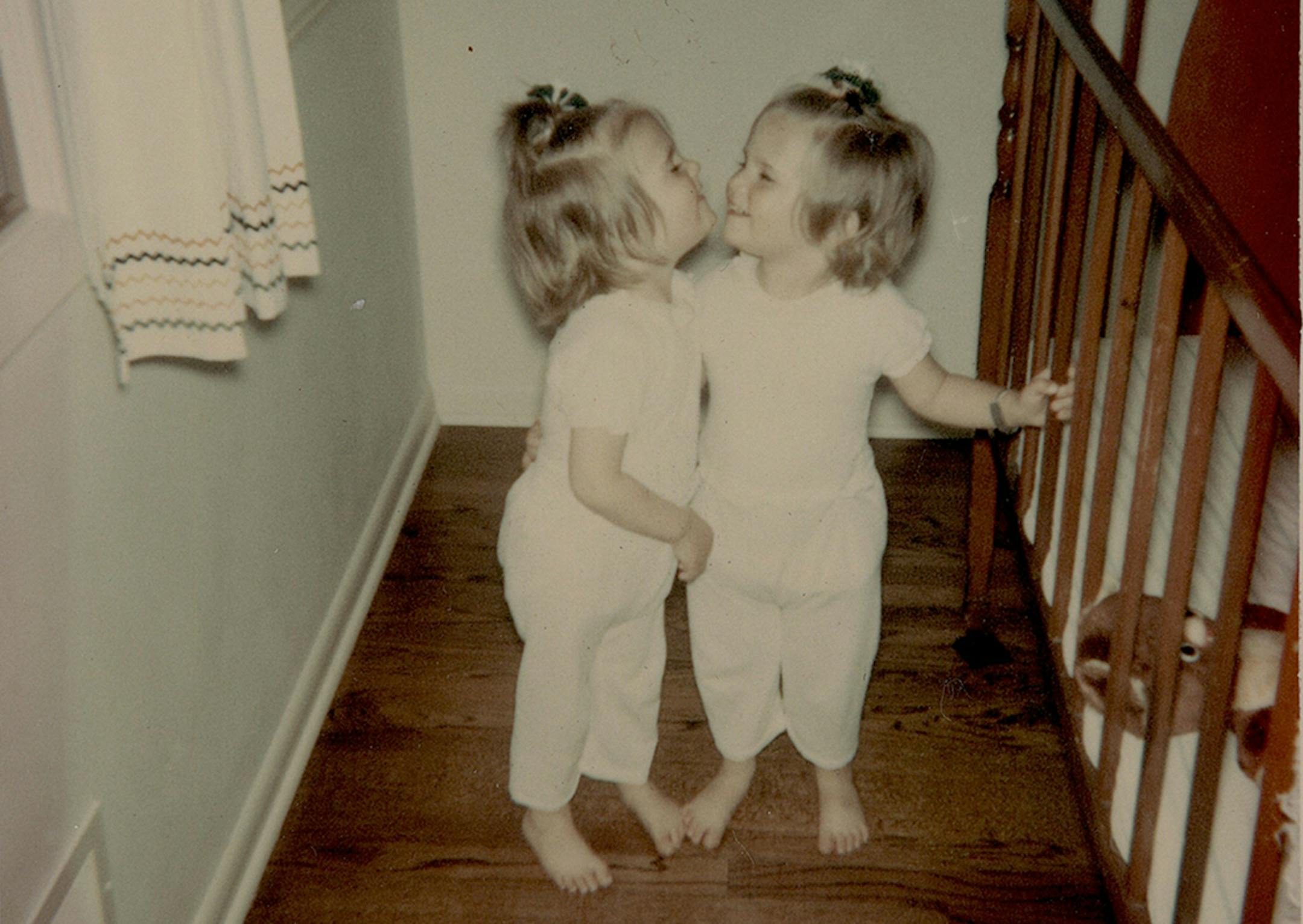 My apologies if you don’t accept more than one submission for the InFocus photo series. I’m attaching a couple of me and my identical twin sister, Rachel Jensen Mueller. Caption for Photo 1: We spent many summer days at Lake Washington just outside Mankato. We had little patience for our mom's (Vivian Jensen) attempt to put on the Coppertone. (c. 1968?) Caption for Photo 2: We were always figuring out ways to get out of our cribs so we could be together. (c. 1966) Please let me kno