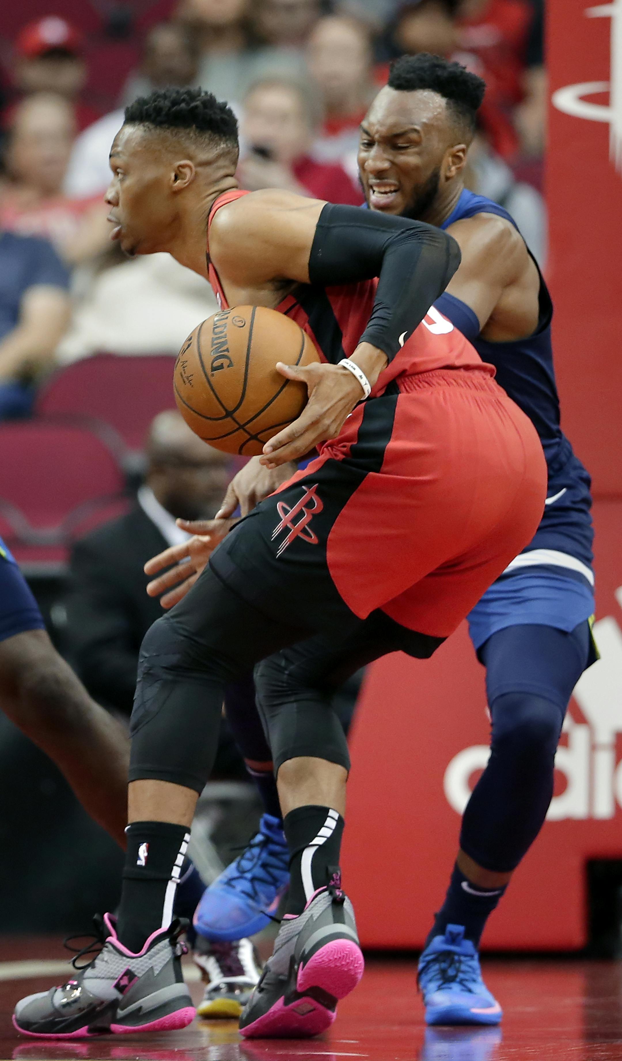 Houston Rockets guard Russell Westbrook, front, looks to pass the ball around Minnesota Timberwolves guard Josh Okogie during the first half of an NBA basketball game Tuesday, March 10, 2020, in Houston. (AP Photo/Michael Wyke)