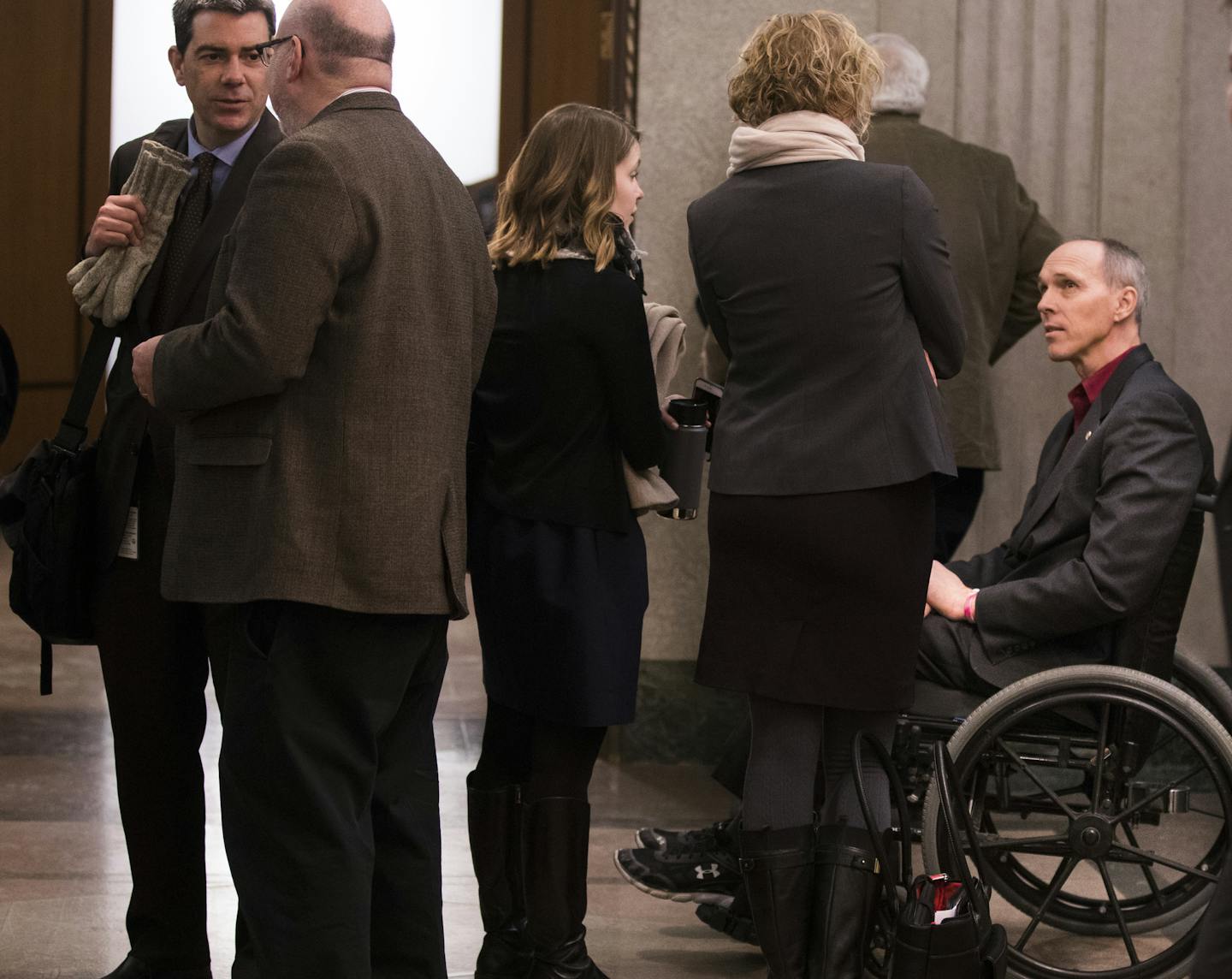 Rep. Rod Hamilton talks with people in the hallway outside the hearing room after a Ways and Means Committee hearing.