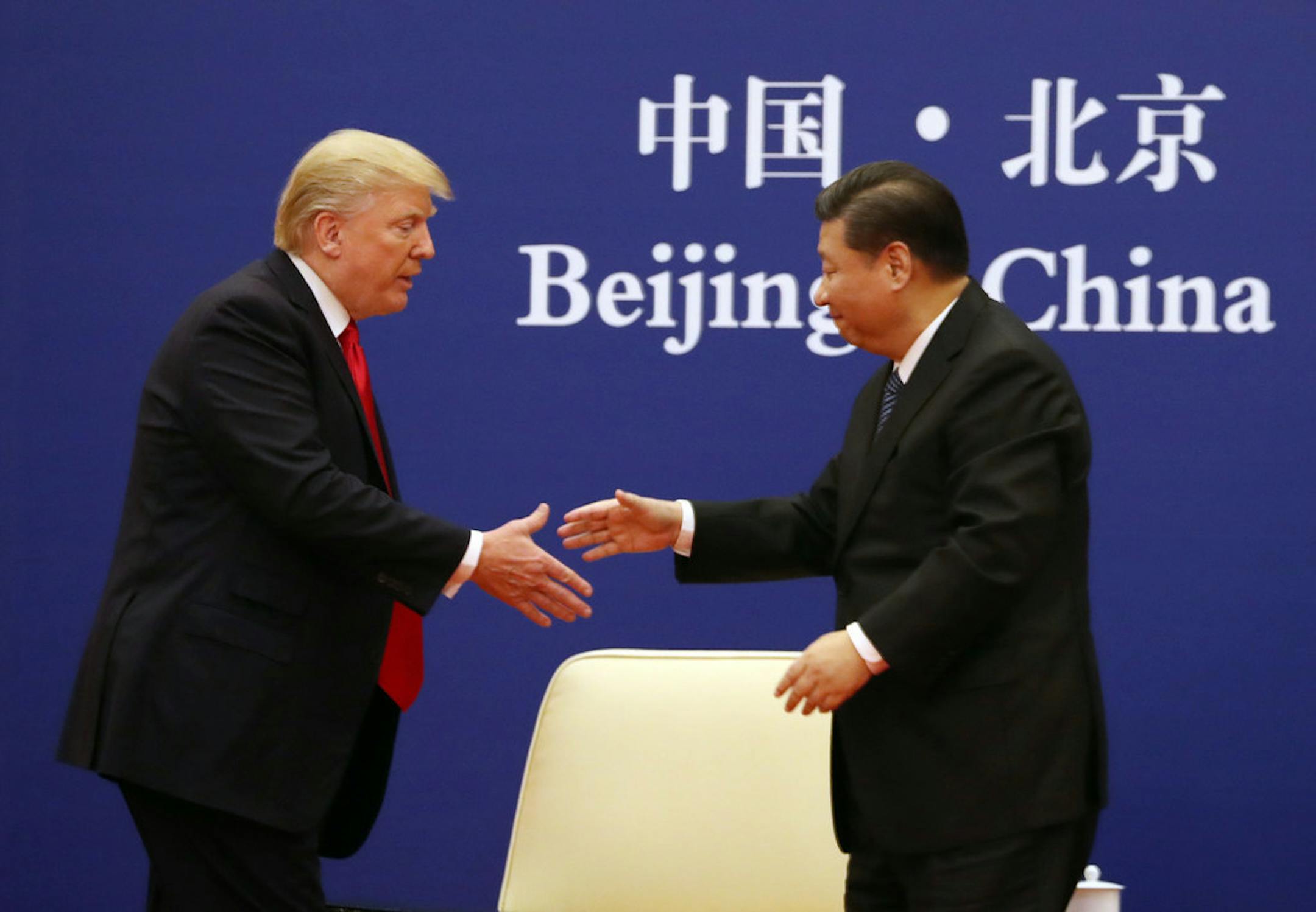 U.S. President Donald Trump, left, and Chinese President Xi Jinping prepare to shake hands during a business event at the Great Hall of the People in Beijing on Thursday.
