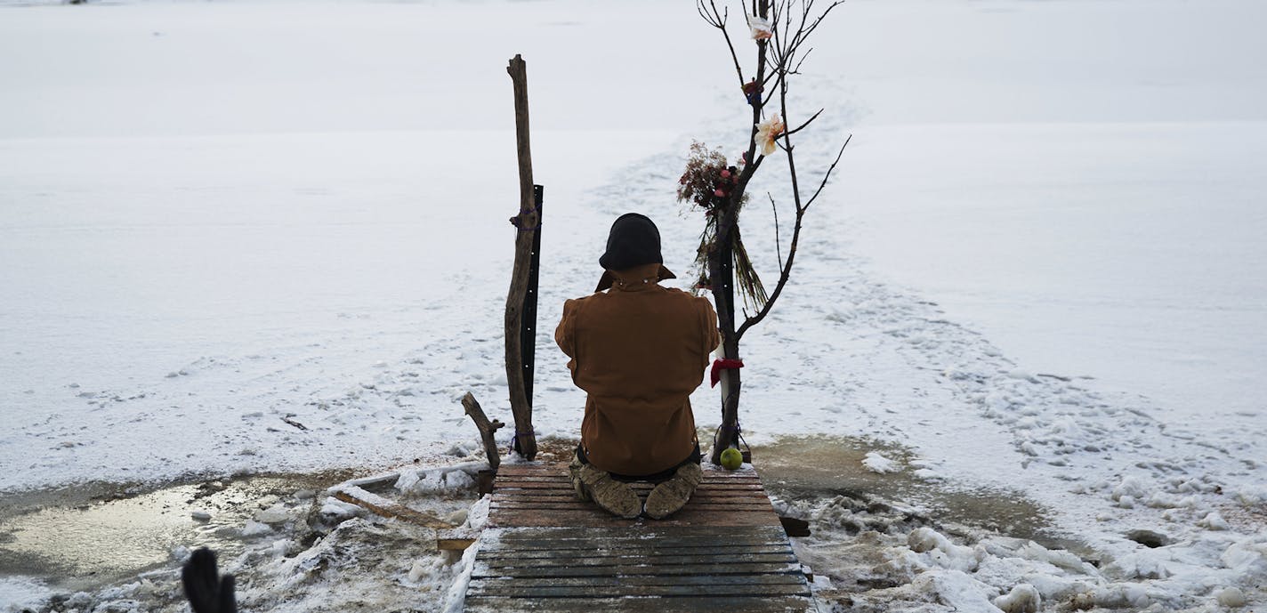 Army veteran Nick Biernacki, of Indiana, prays at the Cannonball River at the Oceti Sakowin camp where people have gathered to protest the Dakota Access oil pipeline in Cannon Ball, N.D., Sunday, Dec. 4, 2016. Tribal elders have asked the military veterans joining the large Dakota Access pipeline protest encampment not to have confrontations with law enforcement officials, an organizer with Veterans Stand for Standing Rock said Sunday, adding the group is there to help out those who've dug in ag