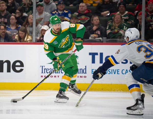 Freddy Gaudreau of the Wild took a shot against St. Louis defenseman Steven Santini on Sunday at Xcel Energy Center.