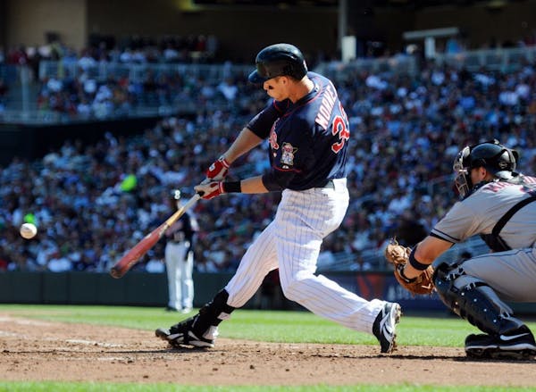 The Twins' Justin Morneau hit a two-run home run against Indians pitcher Corey Kluber as catcher Lou Marson looked on in the third inning Sunday.