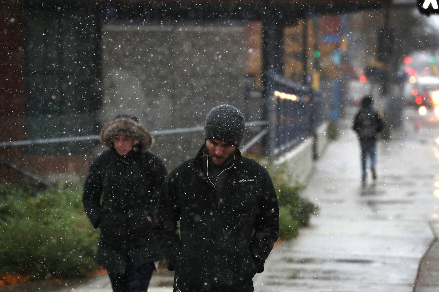 Pedestrians walk down Cedar Avenue in Minneapolis during the first snow of the season. ] LEILA NAVIDI &#xef; leila.navidi@startribune.com BACKGROUND INFORMATION: First snow of the season in Minneapolis on Friday, October 27, 2017.