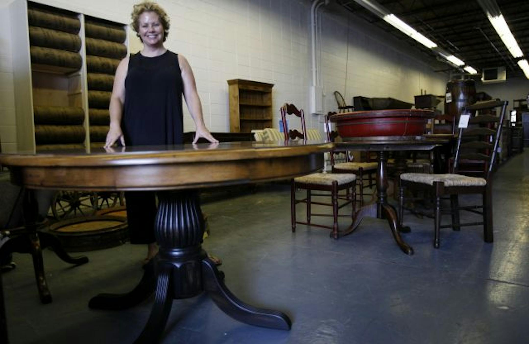 Kim Schmid of Edina poses for a portrait with her dining room table that was broken by the moving company she hired. Schmid had the table repaired at Euronest Furniture where she bought it.