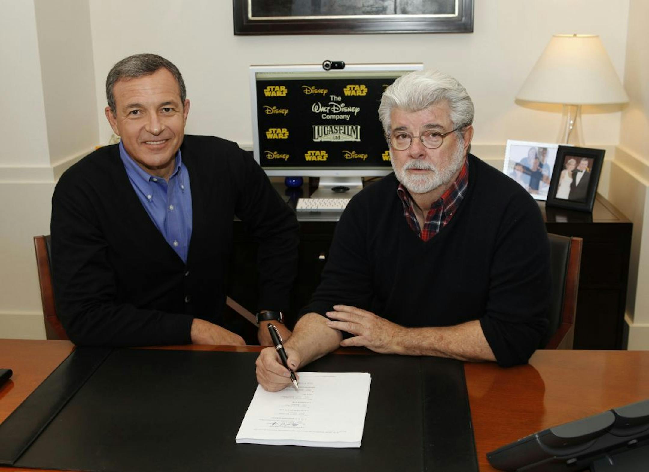 In this publicity photo released by Disney, Robert A. Iger, left, chairman and CEO, The Walt Disney Company, and George Lucas, chairman and founder, Lucasfilm, sign the agreement for The Walt Disney Company to acquire Lucasfilm Ltd. on Tuesday, Oct. 30, 2012, in Burbank, Calif. The Walt Disney Co. announced today that it was buying Lucasfilm Ltd. from George Lucas for $4.05 billion. The deal brings Lucasfilm under the Disney banner with other brands including Pixar, Marvel, ESPN and ABC, all com