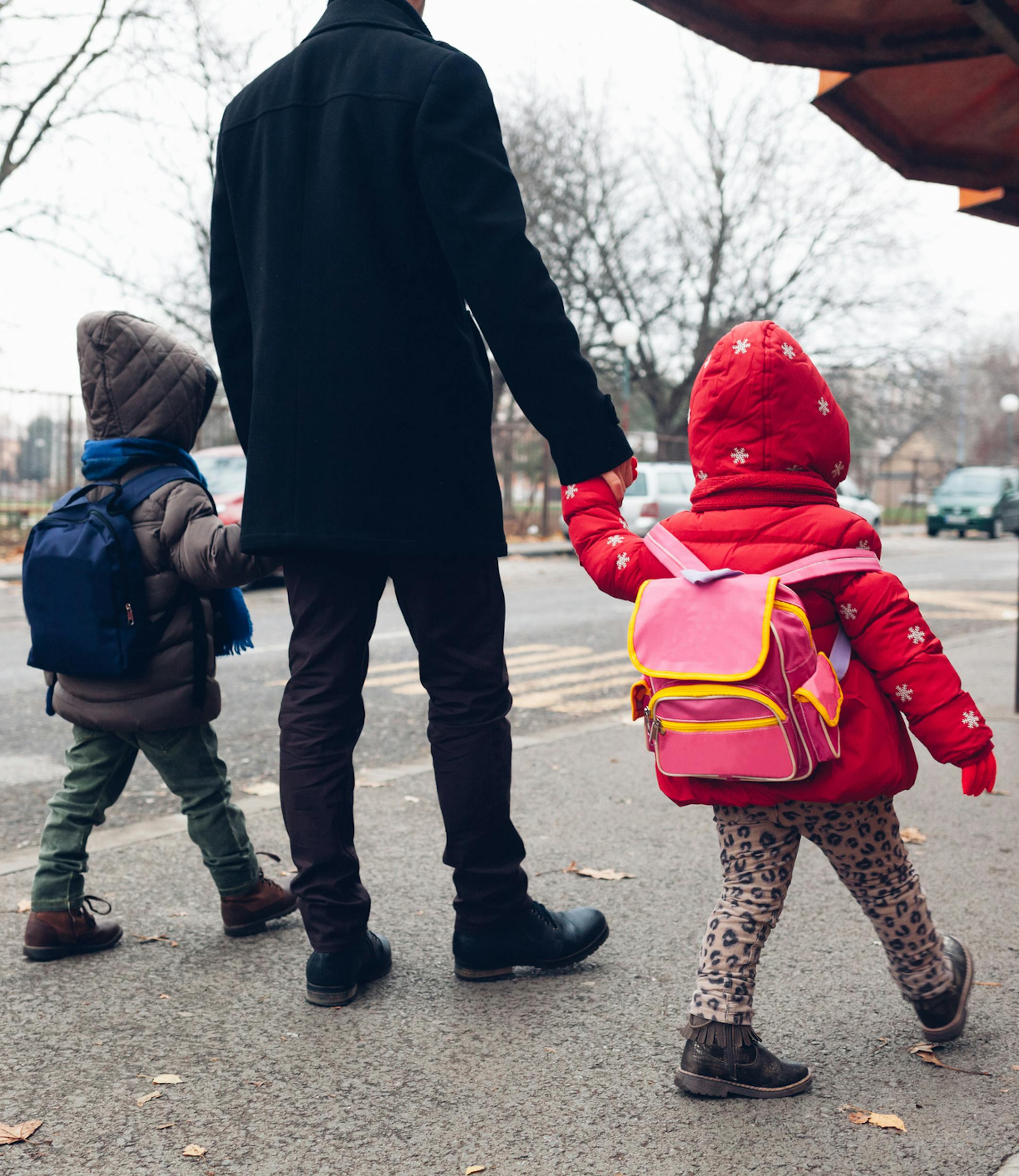 iStock
Dad with kids going to the bus stop.