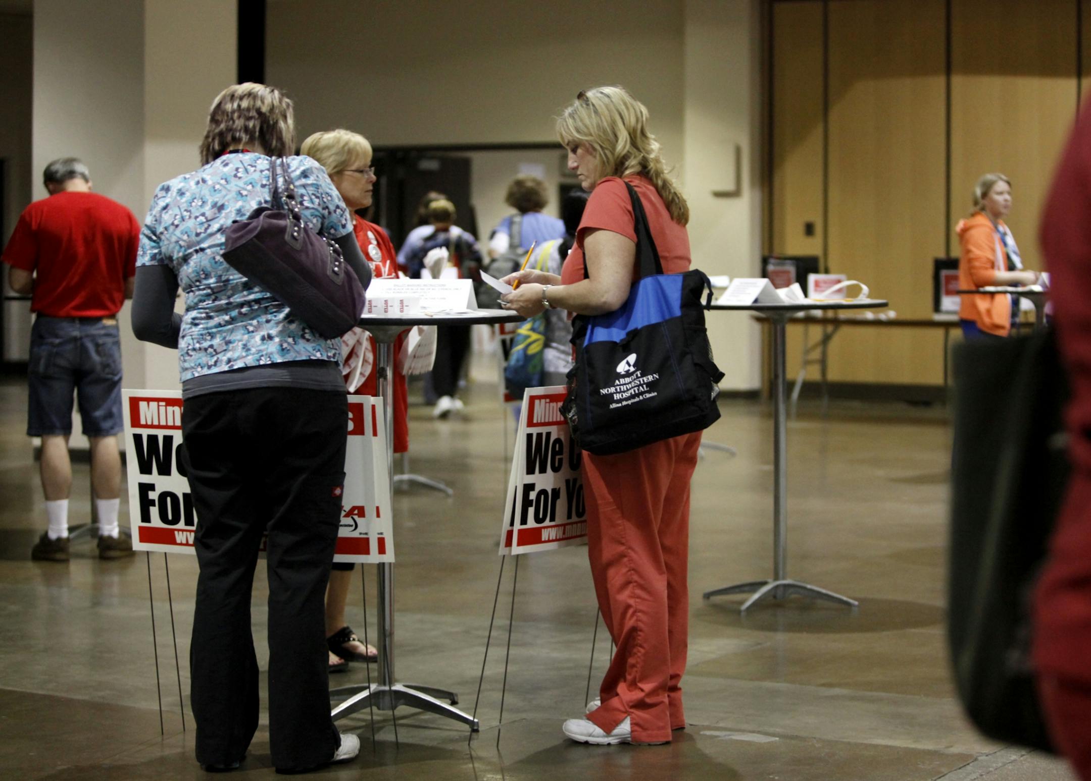 Susan Clasen, a nurse at Abbott Northwestern Hospital, center, casts her ballot.