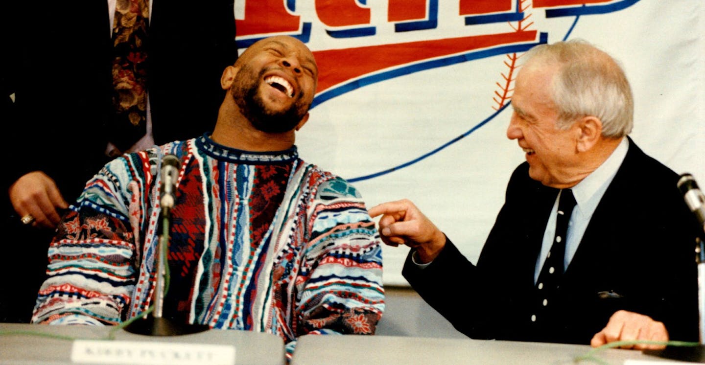 December 4, 1992 Kirby signs with Twins. photo 1. Kirby Puckett left, enjoys the moment after signing a five-year, $30 million contract with Carl Pohlad (left) owner of the Twins. photo 2. Kirby Puckett and his wife Tonya and their daughter Catherine enter a press conference where Puckett resigned with the Twins. December 5, 1992 Jerry Holt, Minneapolis Star Tribune