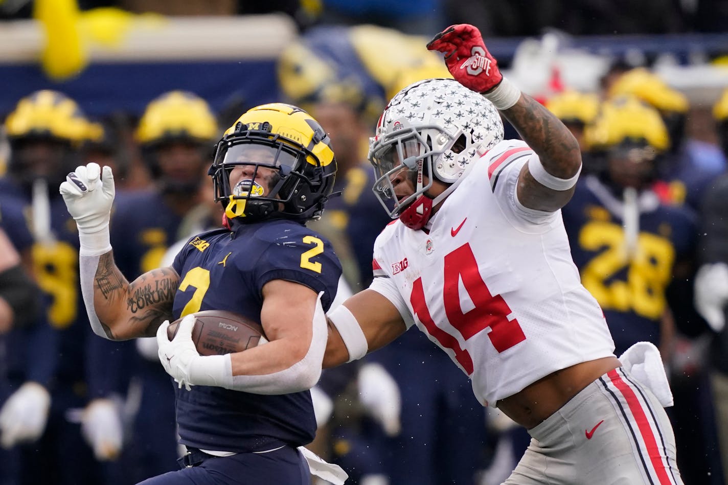 FILE - Michigan running back Blake Corum (2) is chased by Ohio State safety Ronnie Hickman during the second half of an NCAA college football game Nov. 27, 2021, in Ann Arbor, Mich. The Ohio State defense that was shredded by backs Hassan Haskins and Corum for 256 yards last year is vastly improved under new coordinator Jim Knowles. But Corum is better than ever in 2022. (AP Photo/Carlos Osorio, File)