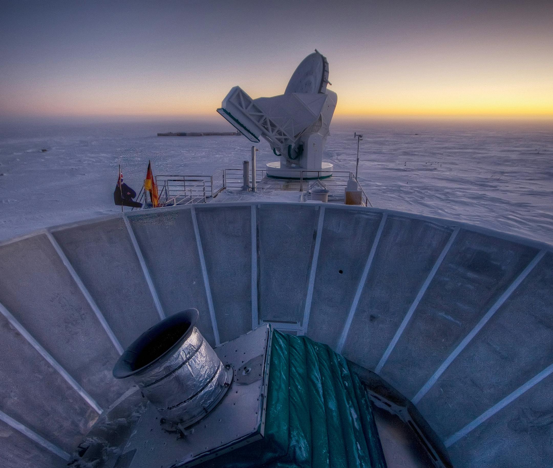 In this 2007 photo provided by Steffen Richter, the sun sets behind the BICEP2 telescope, foreground, and the South Pole Telescope in Antarctica. In the faint glowing remains of the Big Bang, scientists found "smoking gun" evidence that the universe began with a split-second of astonishingly rapid growth from a seed far smaller than an atom. To find a pattern of polarization in the faint light left over from the Big Bang, astronomers scanned about 2 percent of the sky for three years with the BI