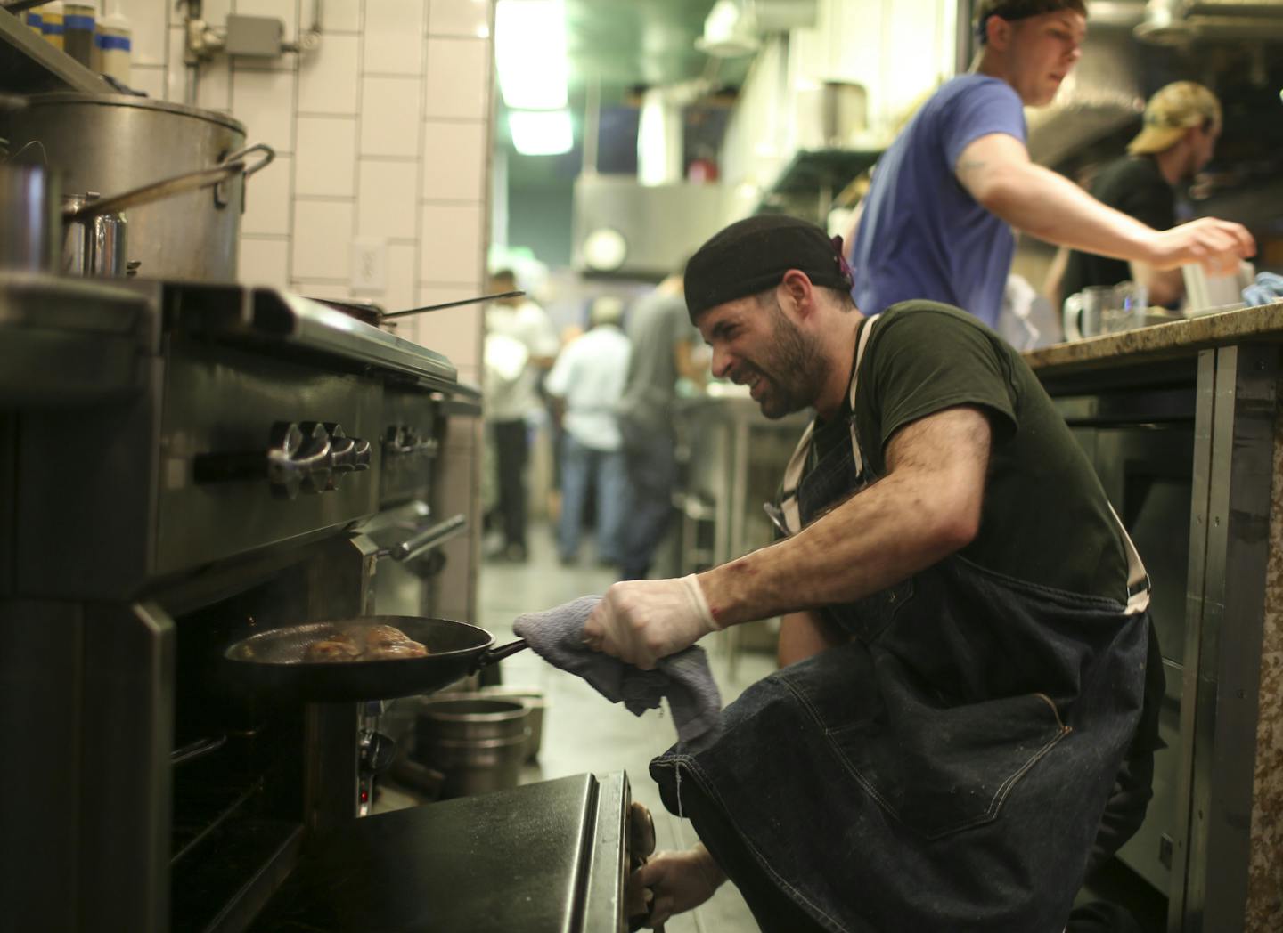 Cook Tom Dokman put quail in the oven at Travail in Robbinsdale, one of many Twin Cities restaurants dealing with a chef shortage.