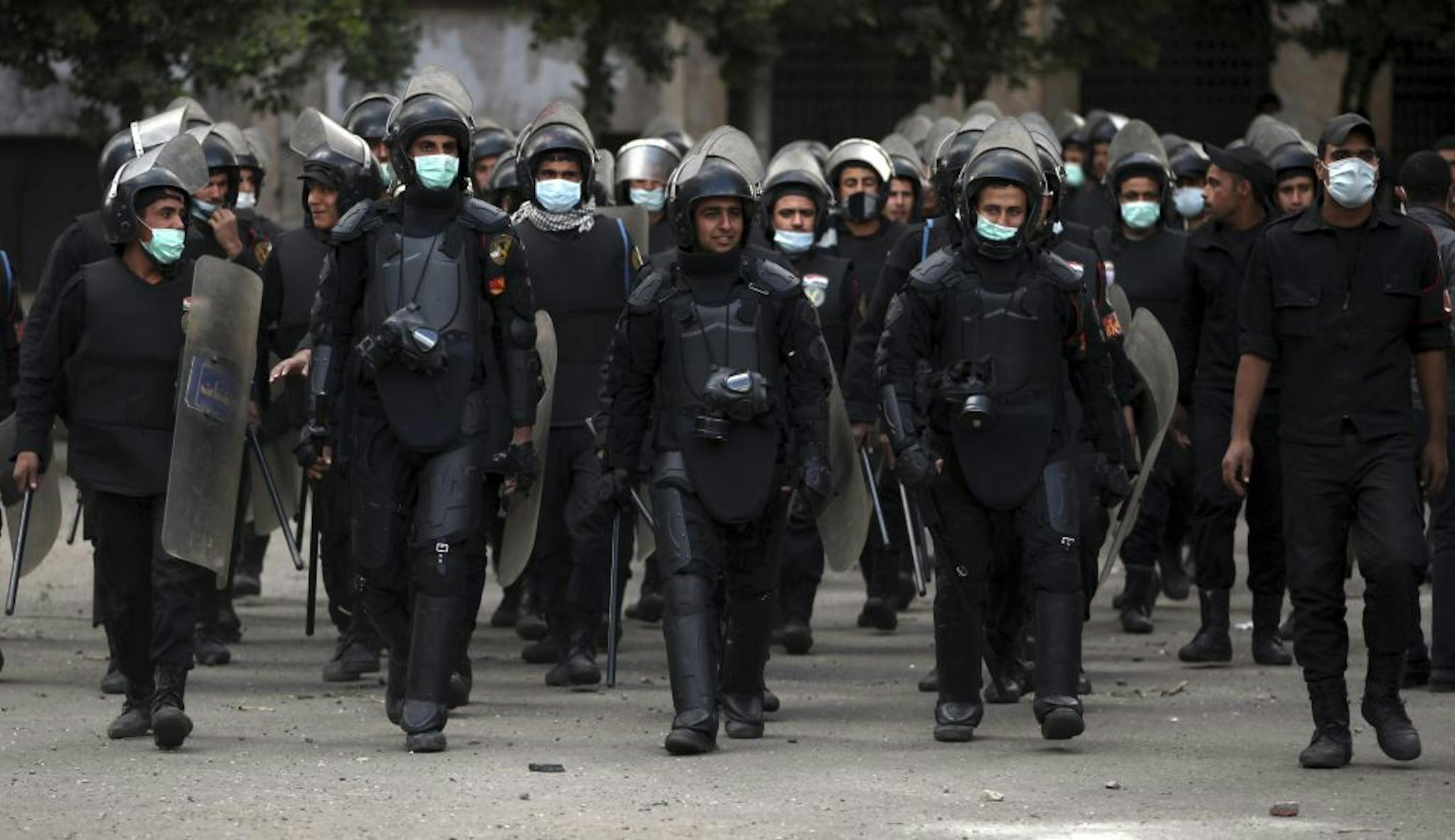 Egyptian riot police march during clashes with protesters, not seen, near Tahrir Square in Cairo, Egypt, Wednesday, Jan. 30, 2013. Egypt's liberal opposition leader called for a broad national dialogue with the Islamist government, all political factions and the powerful military on Wednesday, aimed at stopping the country's eruption of political violence that has left scores dead in the past week.