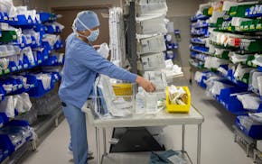 Central Processing Tech FNU DanzengQupi grabs supplies for a surgery at Hennepin County Medical Center in Minneapolis on May 14.
