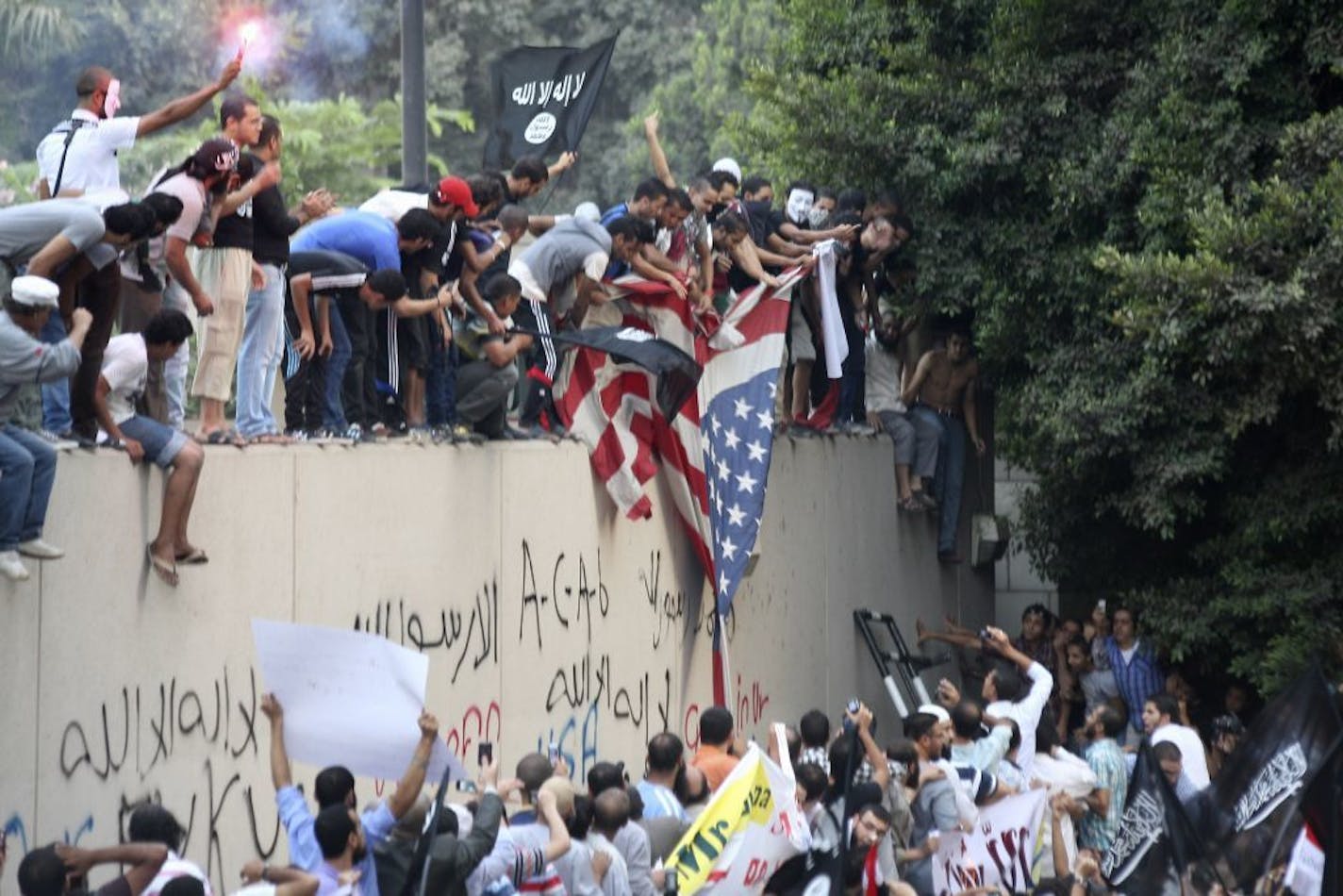 Protesters destroy an American flag pulled down from the U.S. embassy in Cairo, Egypt, Tuesday.