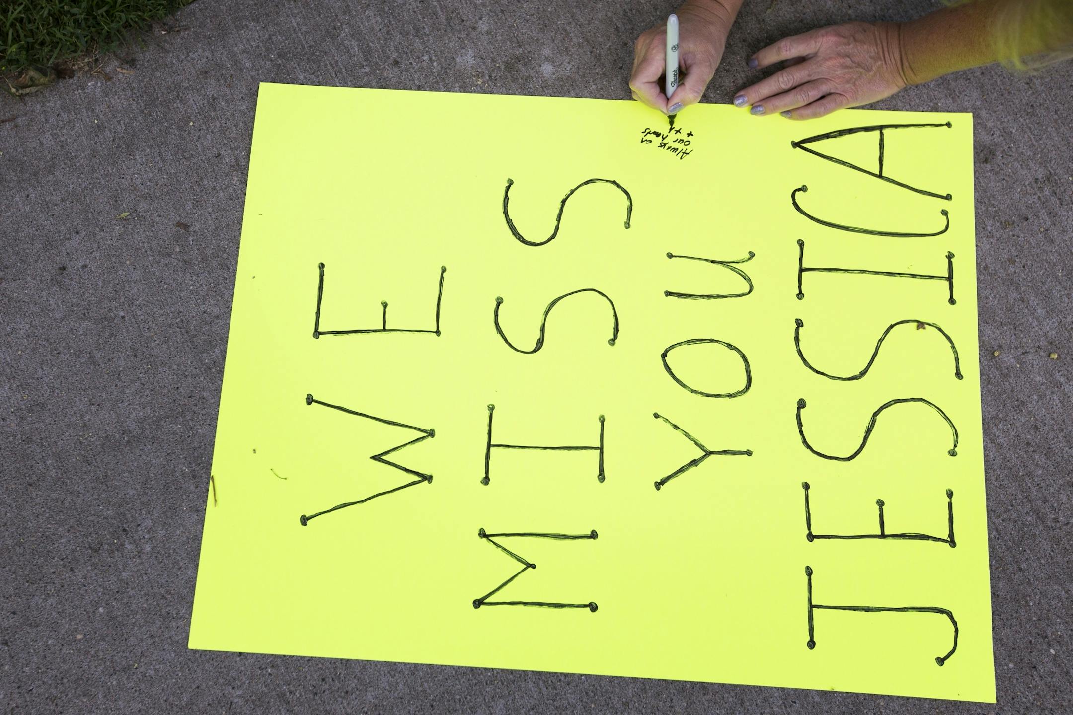 A family member writes a message to Jessica Hanson during a memorial gathering.