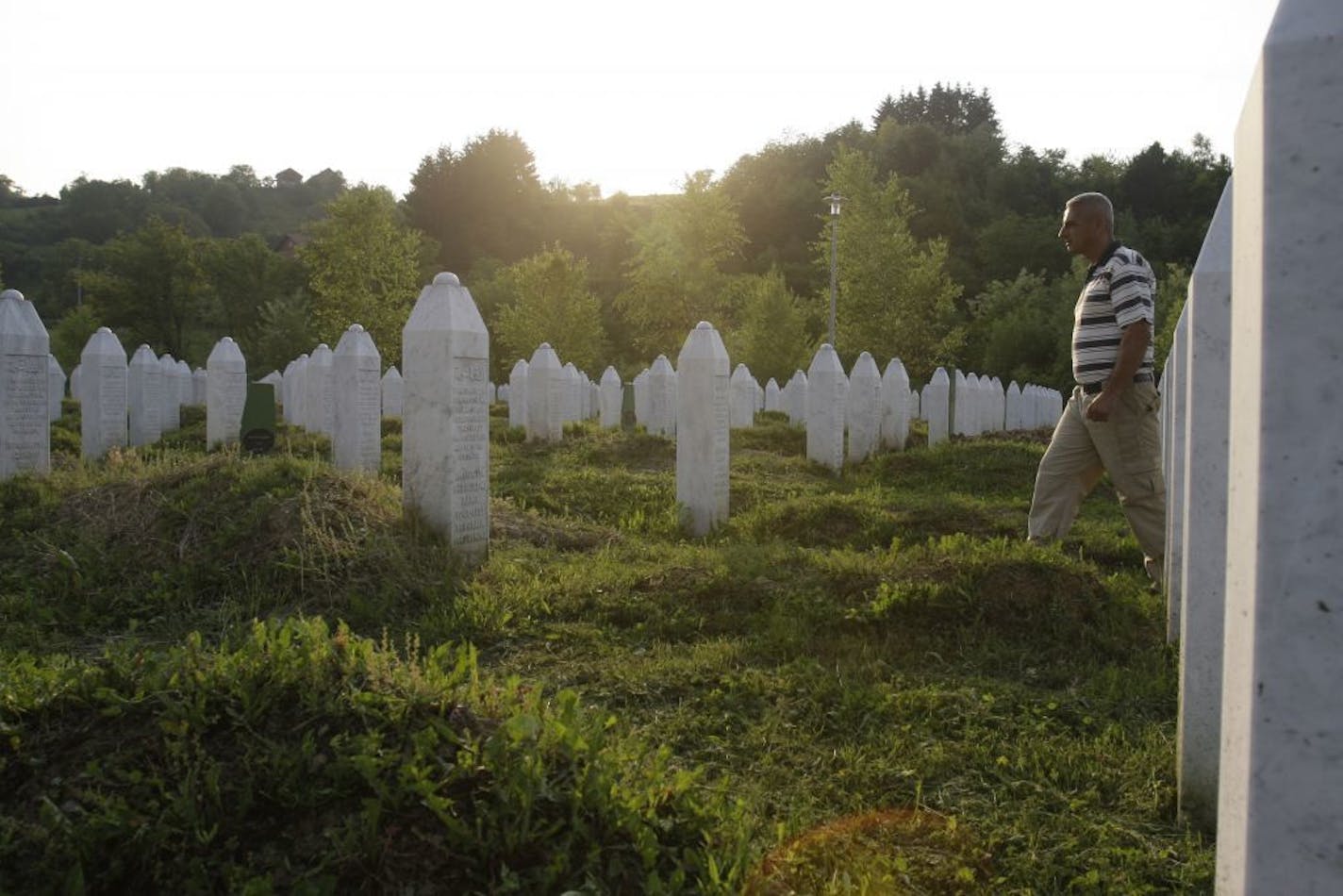 Bosnian Muslim man Azer Ibric walks among grave stones searching for grave of his relative at the memorial center Potocari near Srebrenica, 170 kms north east from Sarajevo, Bosnia, on Thursday May 26, 2011. Gen. Ratko Mladic, the brutal Bosnian Serb general suspected of leading the bloody massacre of 8,000 Muslim men and boys, was arrested in an early morning raid Thursday May 26, 2011, in Serbia after more than a decade hiding from genocide charges, the country's president said.