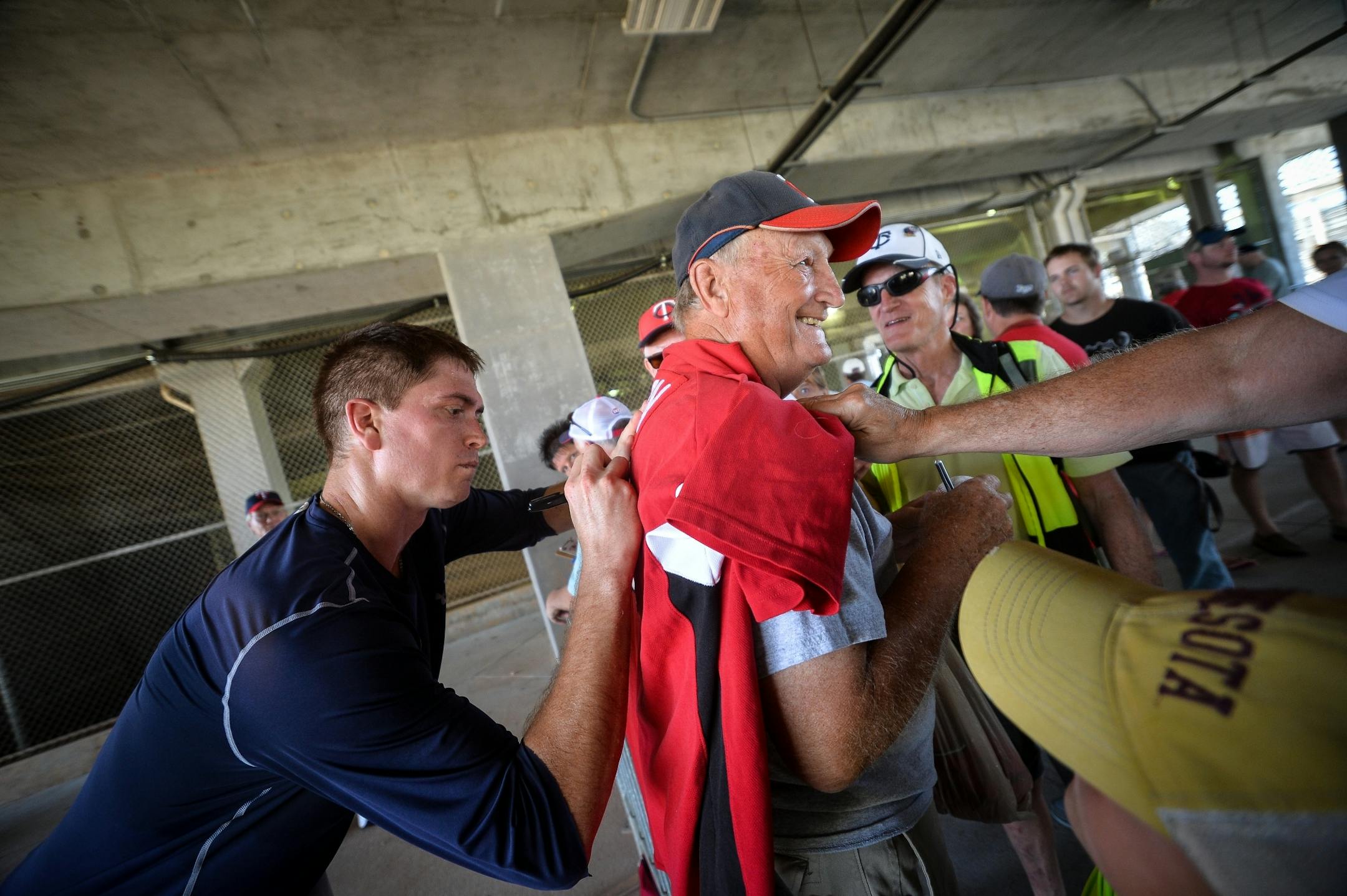 Minnesota Twins starting pitcher Kyle Gibson (44) signed an autograph on the back of the shirt of Gordy Anderson, of Mankato, Wednesday.