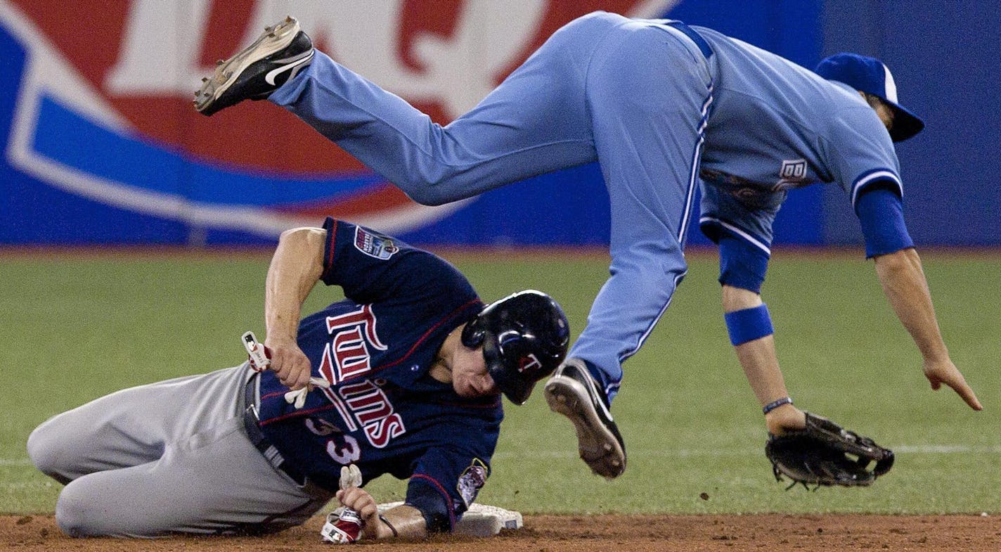 Toronto Blue Jays' John McDonald,right, collides with Minnesota Twins' Justin Morneau at second base after Twins' Michael Cuddyer grounds into fielder's choice during eight inning of their baseball game in Toronto Wednesday, July 7, 2010. (The Canadian Press,Chris Young) ORG XMIT: MIN2013083121373442