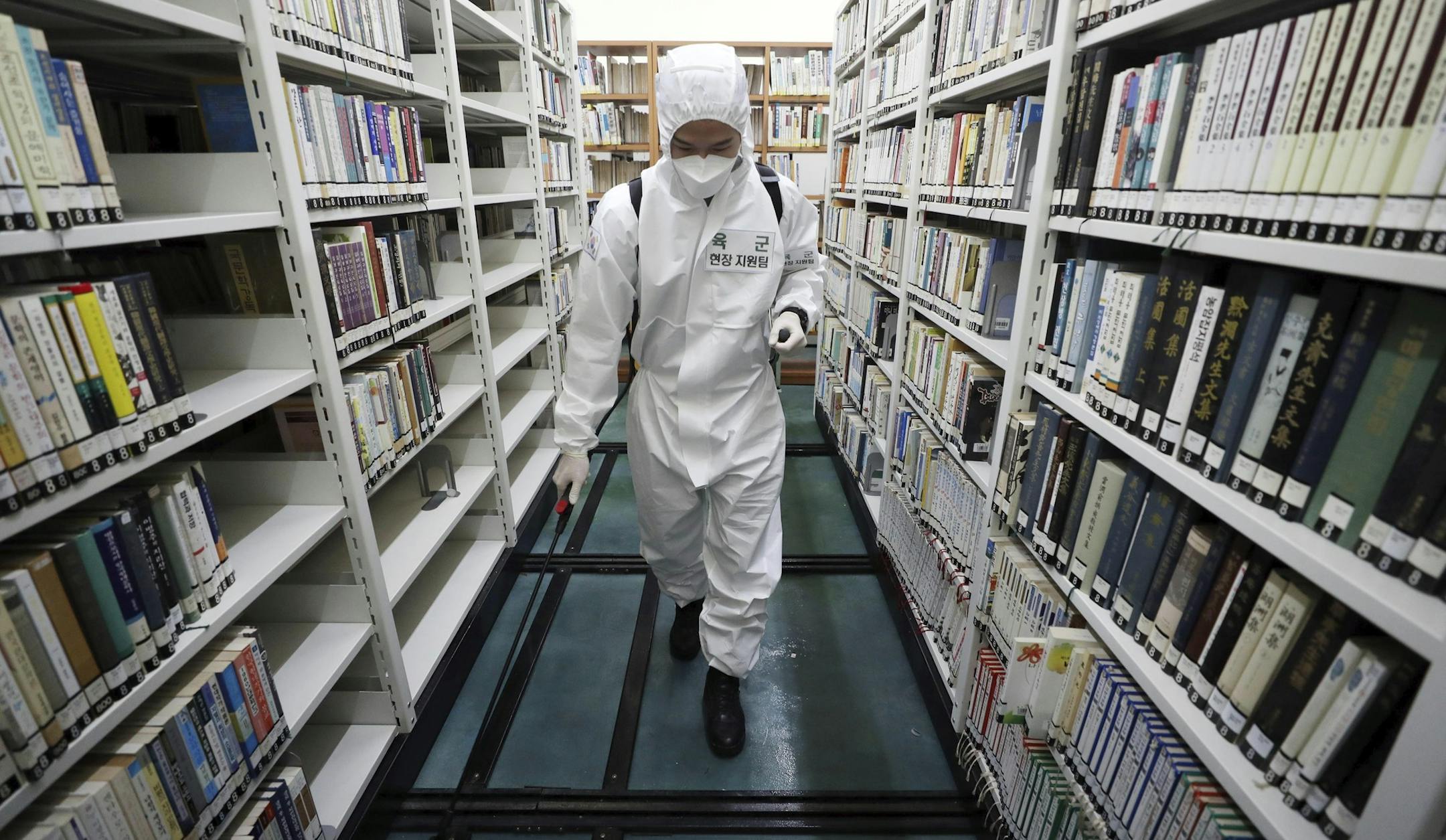 An army soldier sprays disinfectant to curb the spread of the coronavirus at a library in Daegu, South Korea, Wednesday, March 25, 2020. For most people, the new coronavirus causes only mild or moderate symptoms, such as fever and cough. For some, especially older adults and people with existing health problems, it can cause more severe illness, including pneumonia.(Kim Hyun-tae/Yonhap via AP)