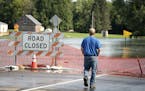 A utilities worker took in the flooding of the Des Moines River in Currie, Minn. The state is seeking federal disaster aid for 36 counties and one tri