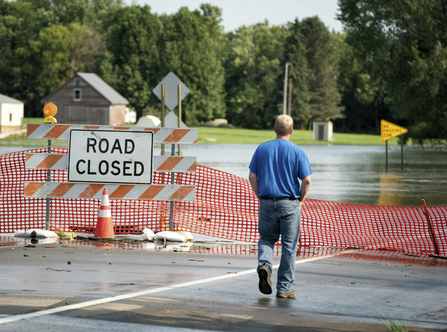 A utilities worker took in the flooding of the Des Moines River in Currie, Minn. The state is seeking federal disaster aid for 36 counties and one tribal nation.