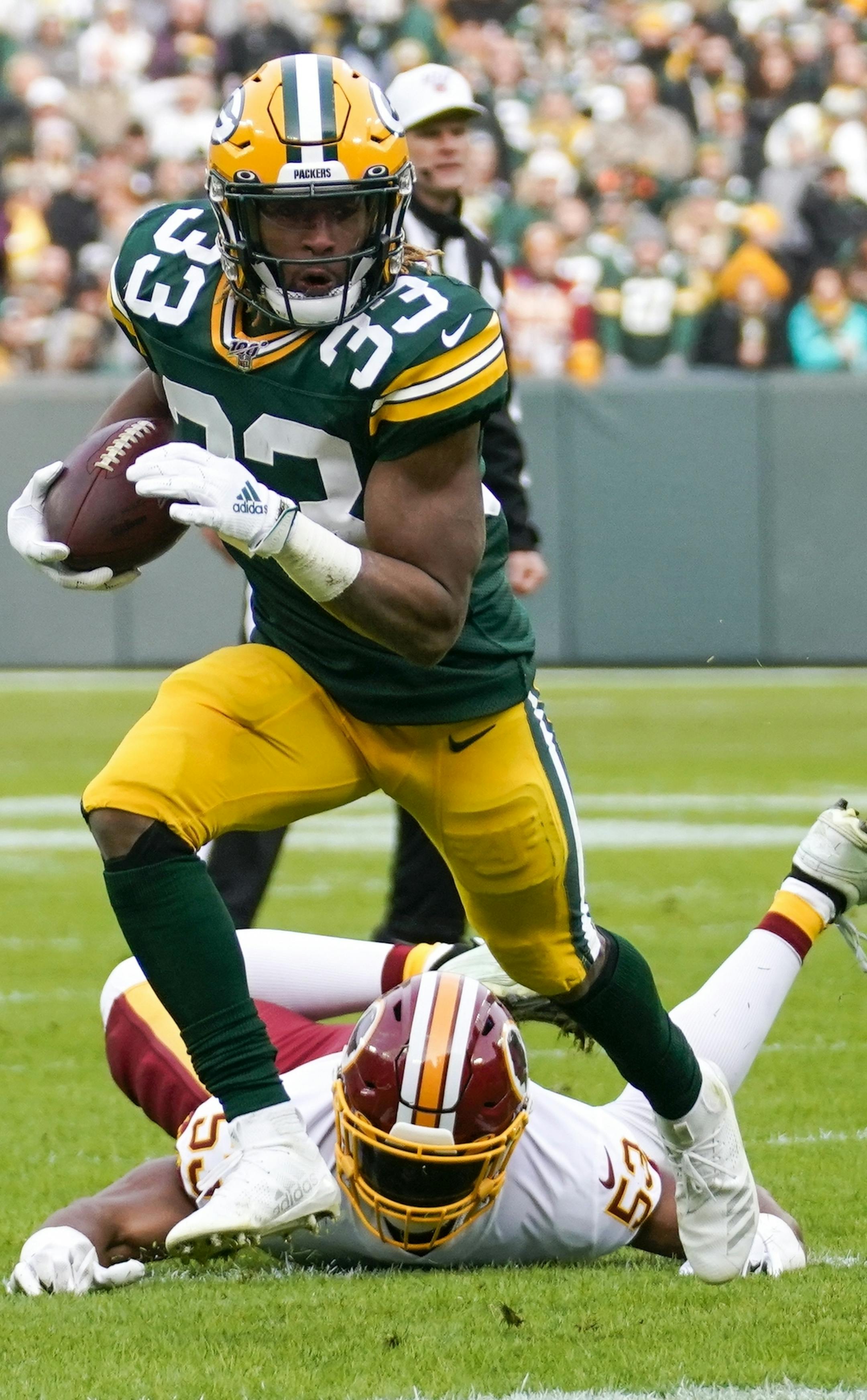 Green Bay Packers' Aaron Jones runs past Washington Redskins' Jon Bostic during the first half of an NFL football game against the Washington Redskins Sunday, Dec. 8, 2019, in Green Bay, Wis. (AP Photo/Morry Gash)
