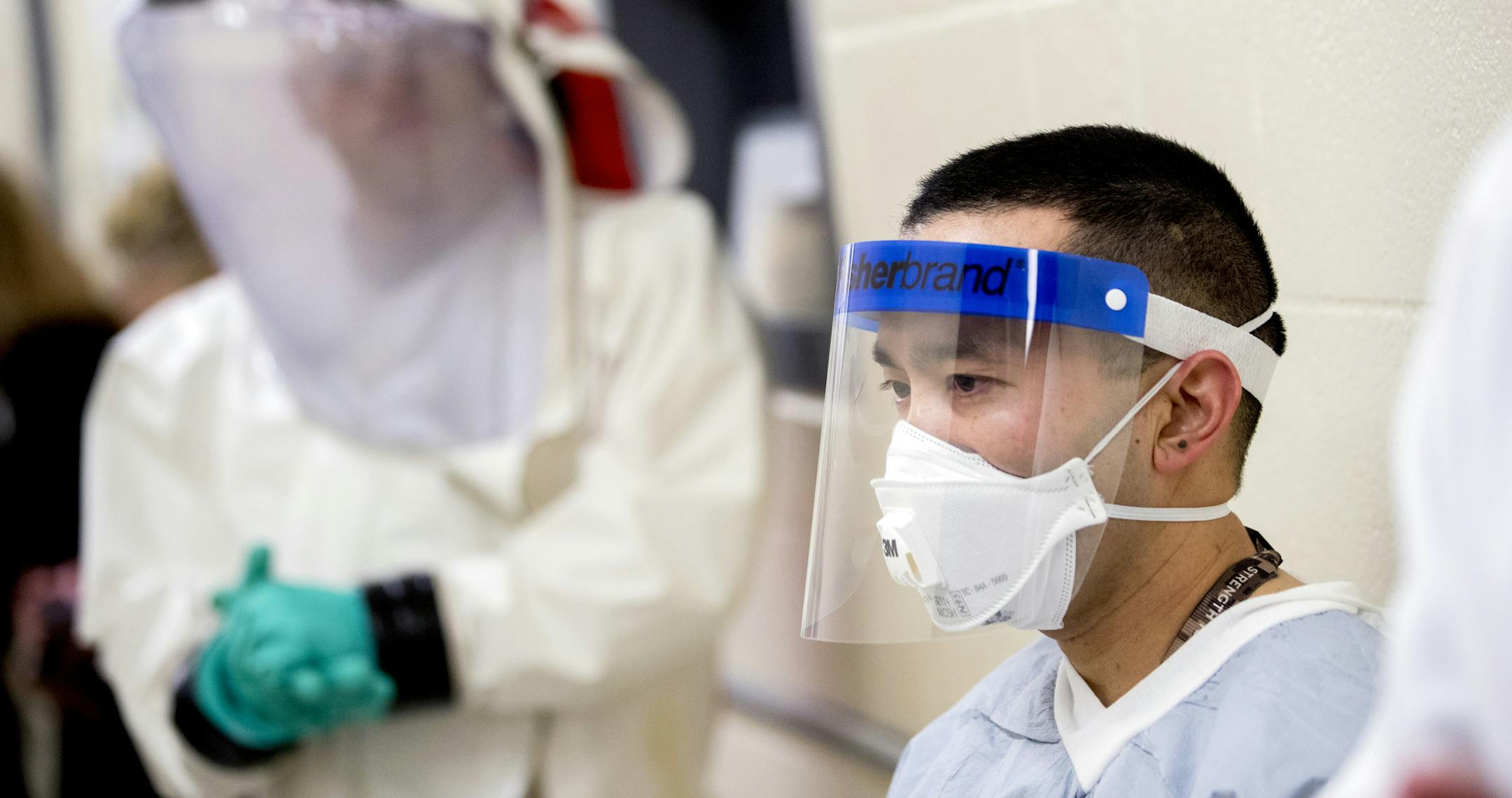 Biological Science Specialists Reginald Clyburn, left, and Mark Ditching, right, wear biosafety level 3 and 4 protective clothing for handling viral diseases at U.S. Army Medical Research and Development Command at Fort Detrick in Frederick, Md., Thursday, March 19, 2020, where scientists are working to help develop solutions to prevent, detect and treat the coronavirus. (AP Photo/Andrew Harnik)