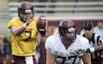 University of Minnesota quarterback Mitch Leidner (7) takes the snap from the shotgun as offensive lineman Foster Bush (77) looks to protect Leidner d