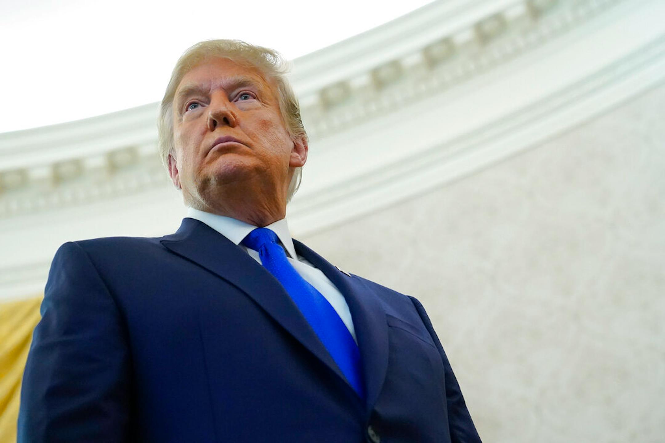 President Donald Trump listens to a reporter's question earlier this month.