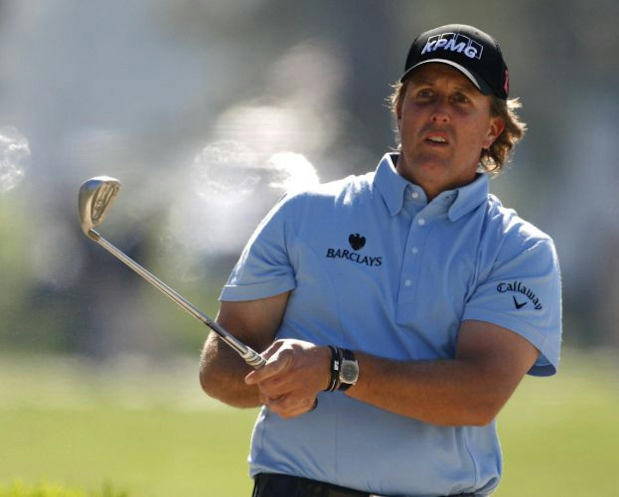 Phil Mickelson looks on after hitting a bunker shot on the sixth hole during the third round of the Farmers Insurance Open golf tournament at Torrey Pines Golf Course on Saturday, Jan. 30, 2010, in San Diego. Mickelson is among at least four players at the tournament using a Ping-Eye 2 wedge that was made 20 years ago and has square grooves. Such grooves now are banned on the tour because of a new U.S. Golf Association regulation this year that irons have V-shaped grooves. The square-groove Ping