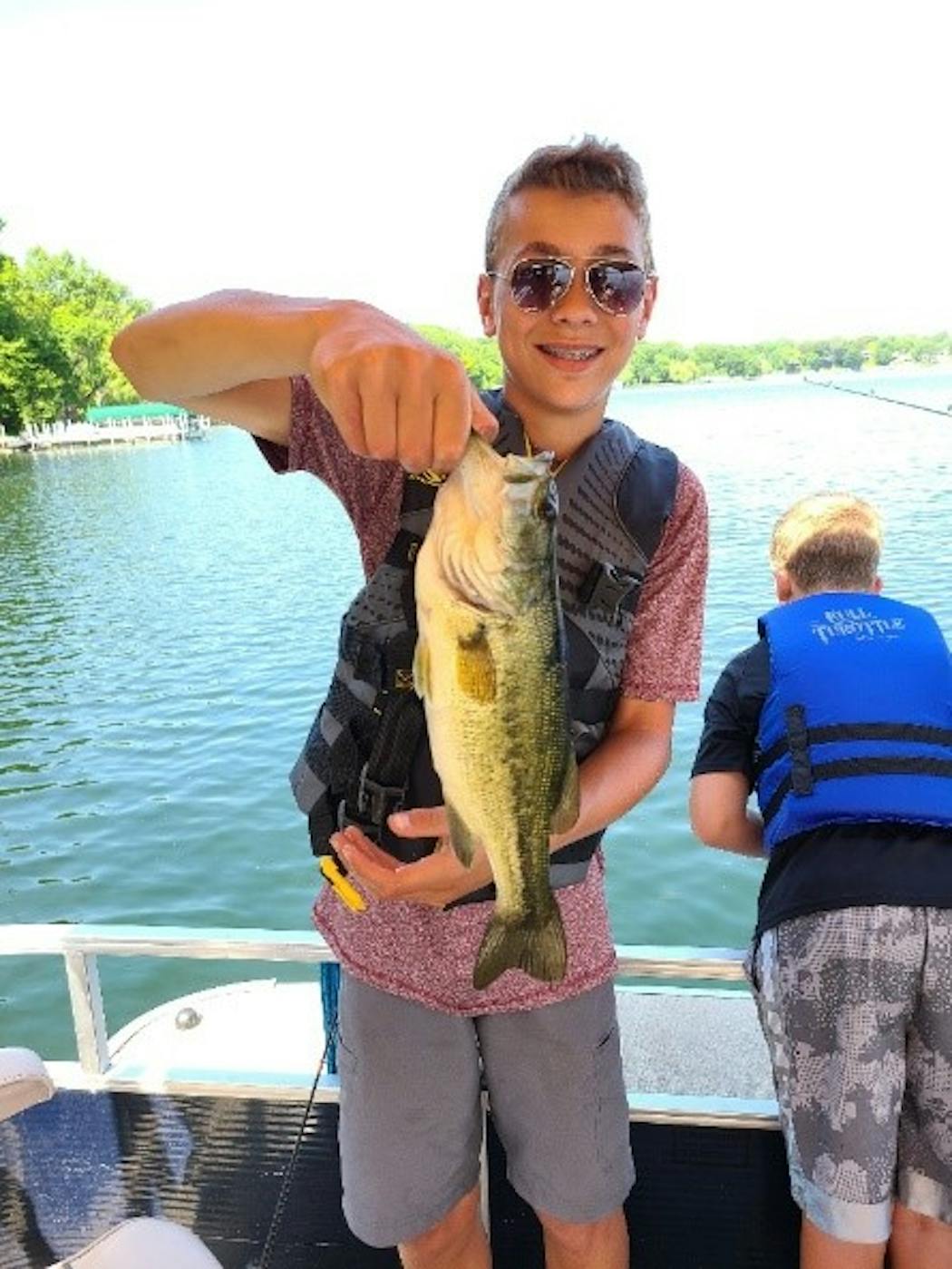 A young participant showed delight as he reeled in a largemouth bass.