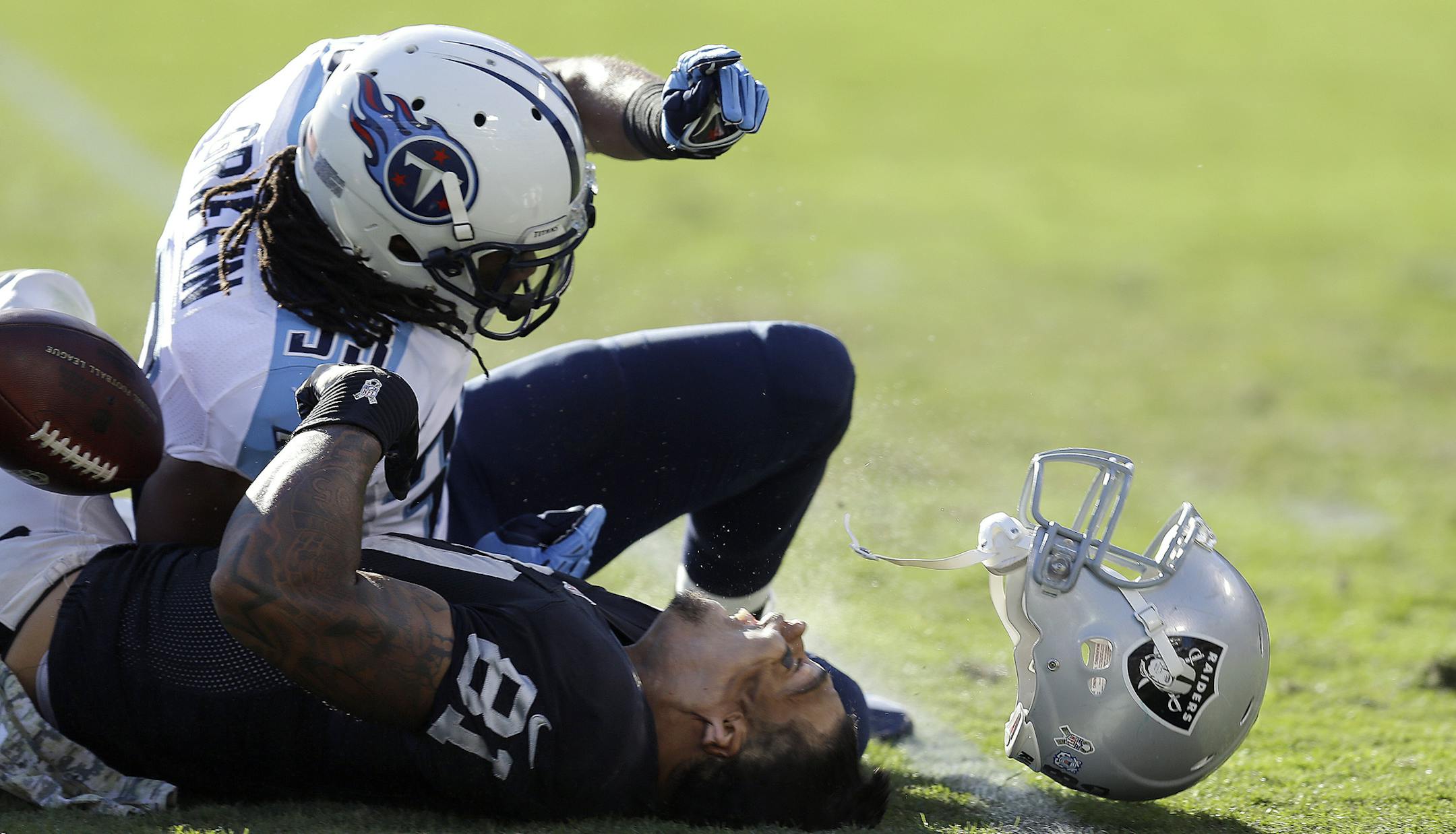 Oakland Raiders tight end Mychal Rivera (81) loses his helmet after being hit by Tennessee Titans free safety Michael Griffin during the second quarter of an NFL football game in Oakland, Calif., Sunday, Nov. 24, 2013. Griffin was penalized on the play and Rivera stayed down for a few minutes before walking off under his own power. He was taken to the locker room and is being evaluated for a head injury. (AP Photo/Ben Margot)