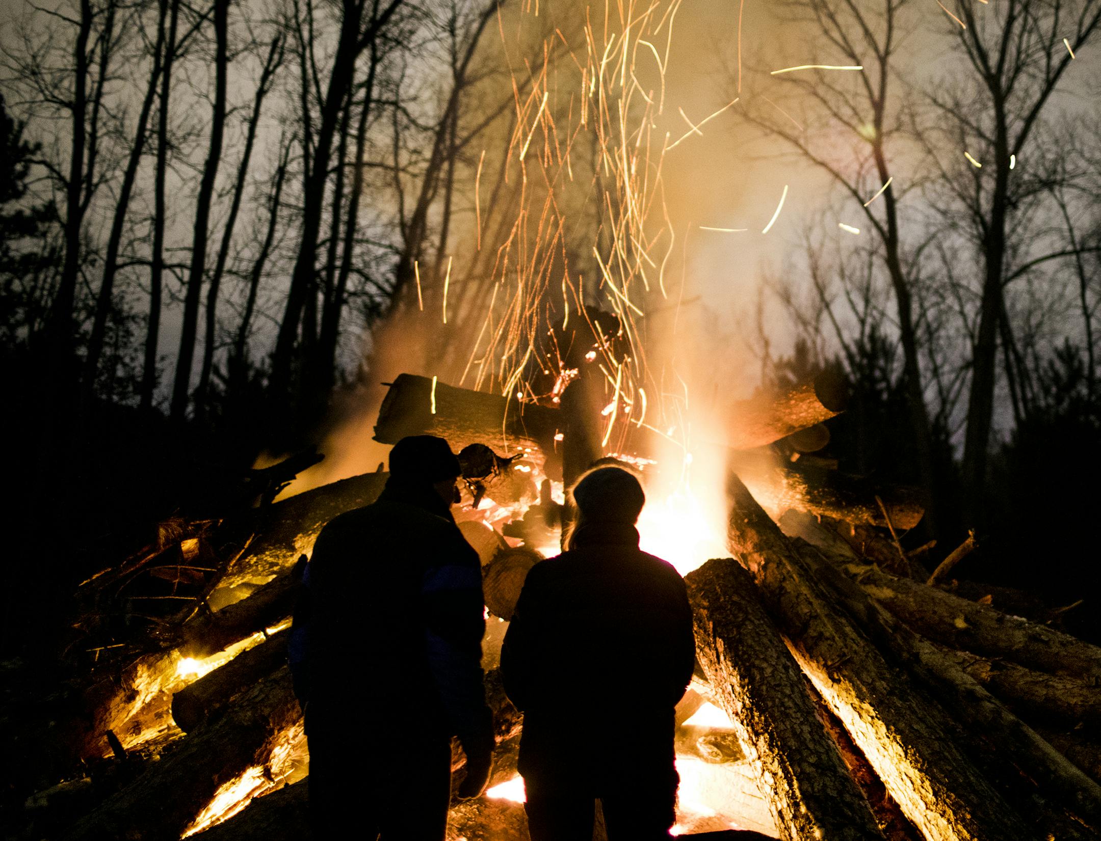 A couple stands in front of the giant bonfire early in the evening. ] LEILA NAVIDI • leila.navidi@startribune.com BACKGROUND INFORMATION: Winter Solstice bonfire at Belwin Conservancy in Afton on Wednesday, December 20, 2017. The event, in it's second year, featured a roaring bonfire, cider, cookies and night hikes. Special guest this year was Impossible Salt, a women-led ensemble of musical storytellers