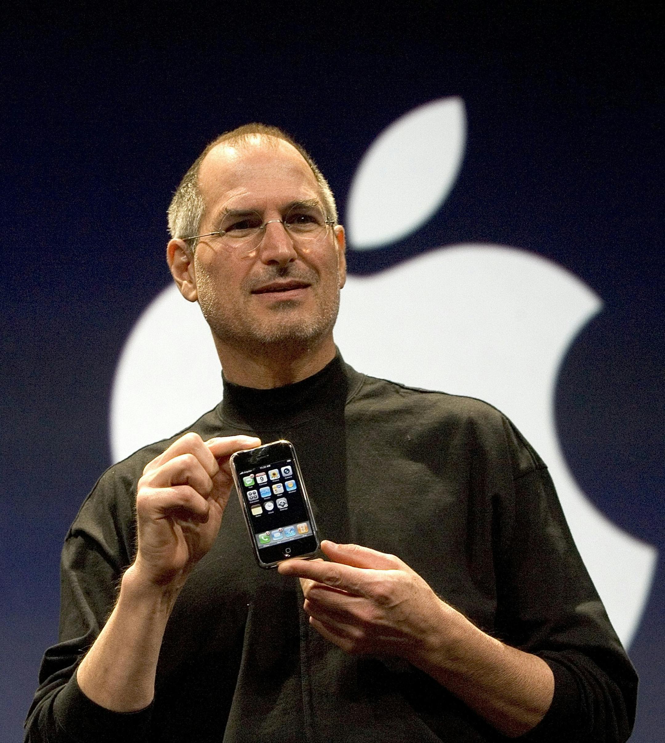 SAN FRANCISCO, CA - JANUARY 9: Apple CEO Steve Jobs holds up the new iPhone that was introduced at Macworld on January 9, 2007 in San Francisco, California. During the keynote Jobs introduced the new iPhone which will combine a mobile phone, a widescreen iPod with touch controls and a internet communications device with the ability to use email, web browsing, maps and searching. The iPhone will start shipping in the US in June 2007. (Photo by David Paul Morris/Getty Images)