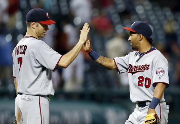 Minnesota Twins' Joe Mauer (7) and Eddie Rosario celebrate the team's 13-5 win against the Cleveland Indians in a baseball game Wednesday, Aug. 3, 201