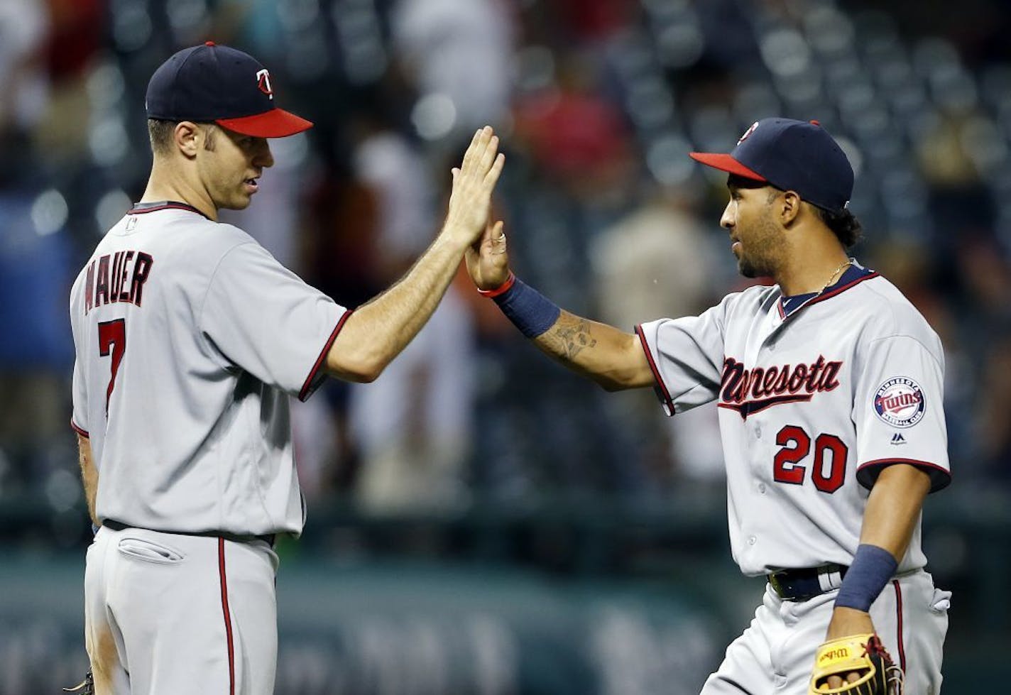 Minnesota Twins' Joe Mauer (7) and Eddie Rosario celebrate the team's 13-5 win against the Cleveland Indians in a baseball game Wednesday, Aug. 3, 2016, in Cleveland.