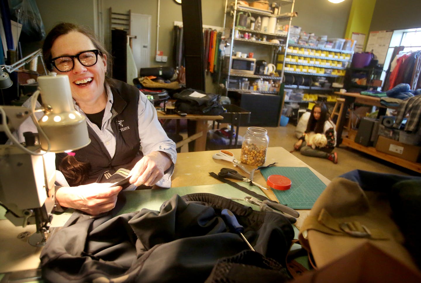 Repair Lair owner Nancy Ford gets a laugh while chatting with a customer while working on replacing a zipper on a pair of bike pants at her Minneapolis consignment shop specializing in outdoor clothing, accessories and repair. Ford was seen working at her East Lake Street business Saturday, April 1, 2017, in Minneapolis, MN.