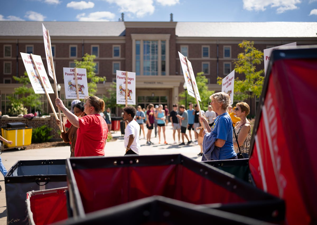 About 100 people picketed in support of University of Minnesota service workers, including janitors and food service employees, on move-in day in Augu