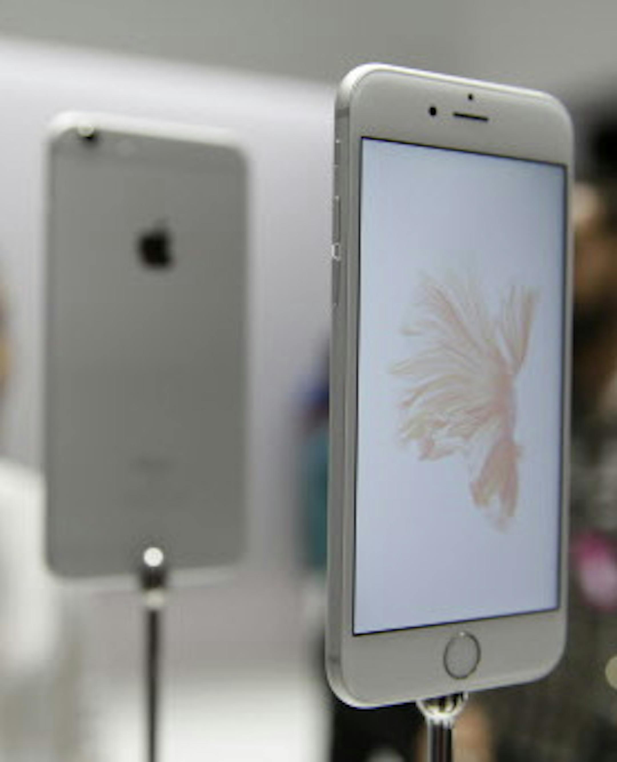 People look over the new Apple iPhone 6s models during a product display following an Apple event Wednesday, Sept. 9, 2015, in San Francisco. Apple staked a new claim to the living room on Wednesday, as the maker of iPhones and other hand-held gadgets unveiled an Internet TV system that's designed as a beachhead for the tech giant's broader ambitions to deliver a wide range of information, games, music and video to the home. (AP Photo/Eric Risberg)