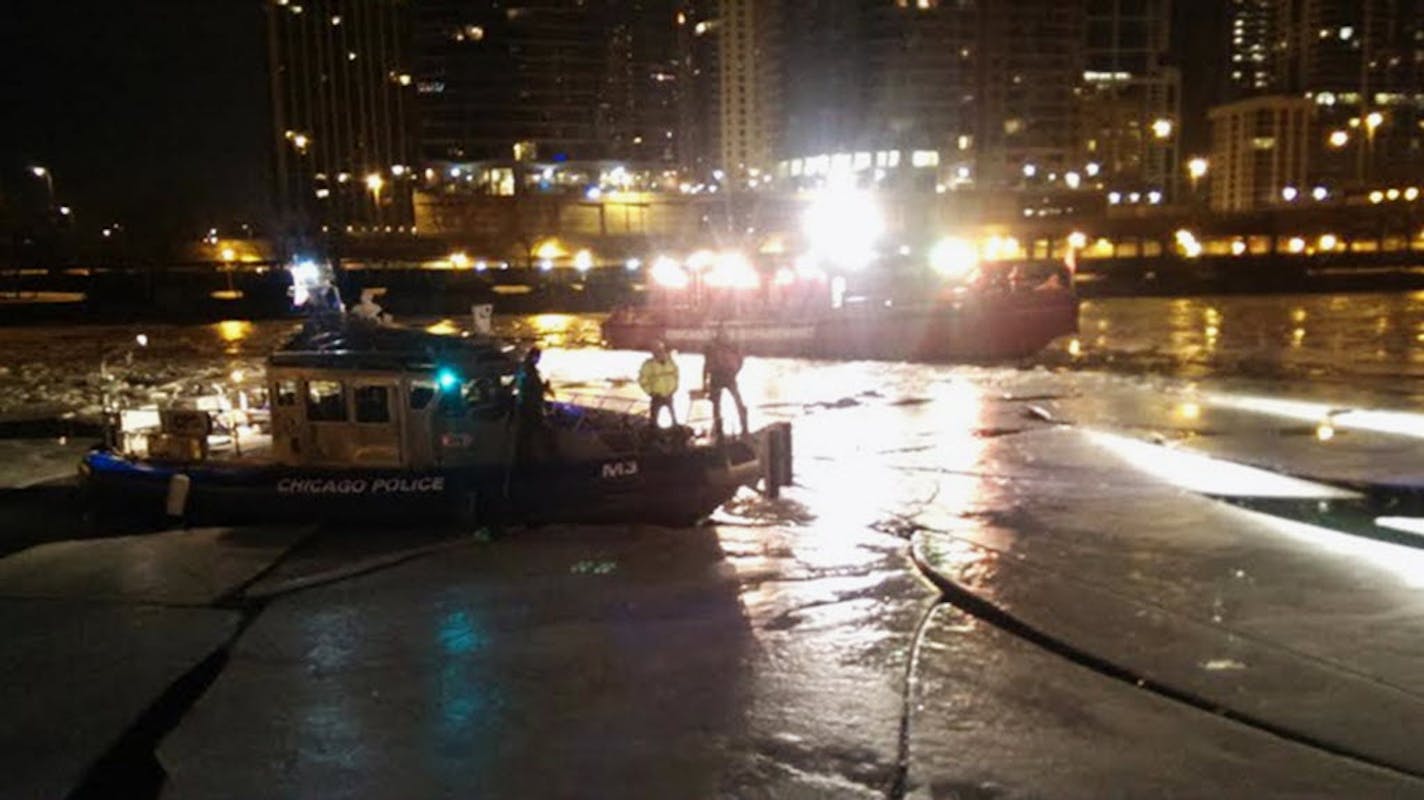 Chicago Police and Fire Department boats are seen on the Chicago River in downtown Chicago early Monday morning, Jan. 14, 2014, where a St. Paul man was pulled from the water after he jumped over a fence to get a cellphone he'd dropped into the water. The man died later at a hospital.