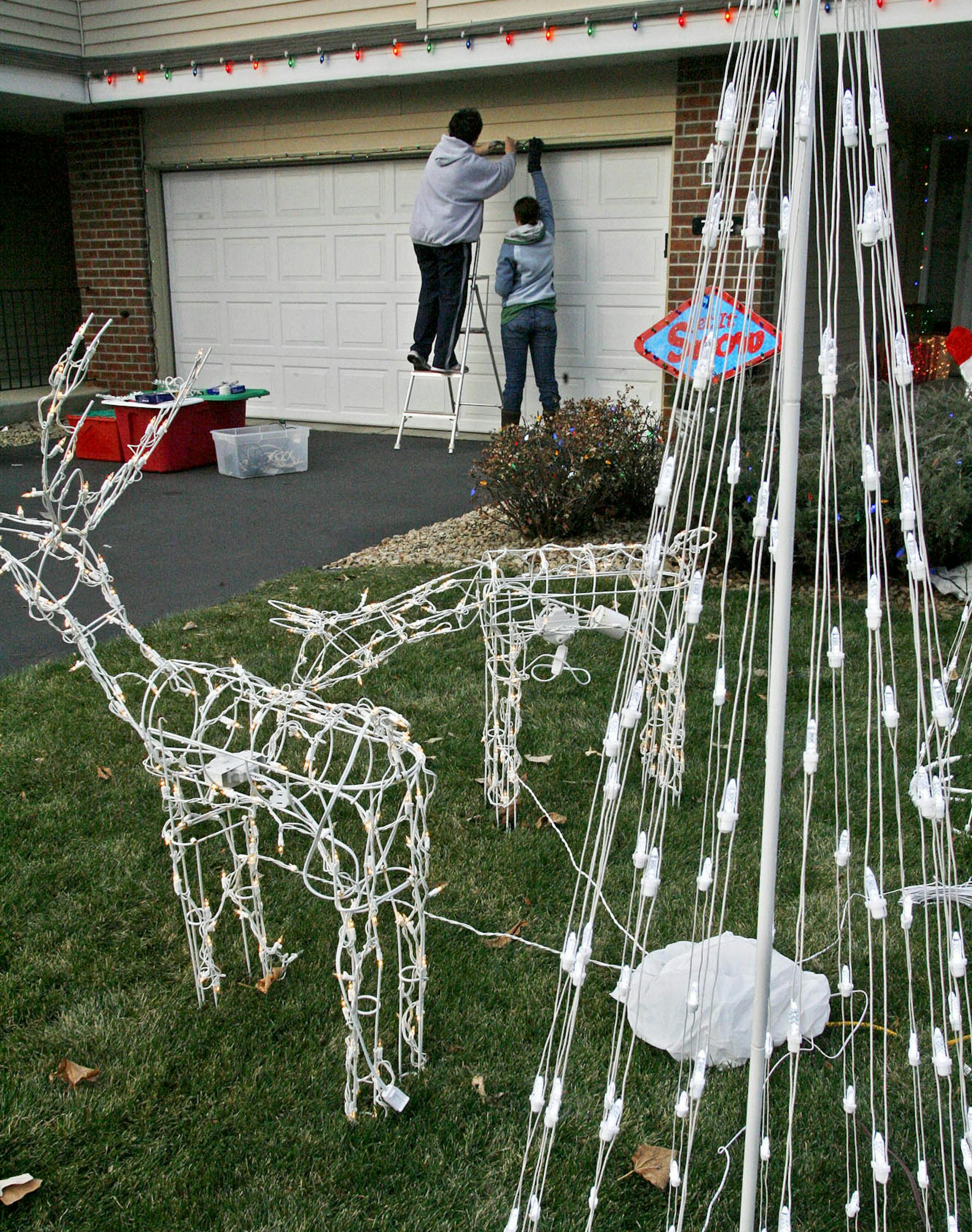 MARLIN LEVISON * mlevison@startribune.com Assign. #00005851A November 23, 2008] - GENERAL INFORMATION: Mary Hayes and family of Inver Grove Heights have switched from traditional large bulbs to smaller more intense led bulbs to decorate the exterior of their town home for the upcoming holiday season. They have invested in about 3,000 led lights to adorn various figures, trees and exterior walls. IN THIS PHOTO: Mary Hayes (on ladder) and daughter Alisha Hayes attach led lights to the garage. The