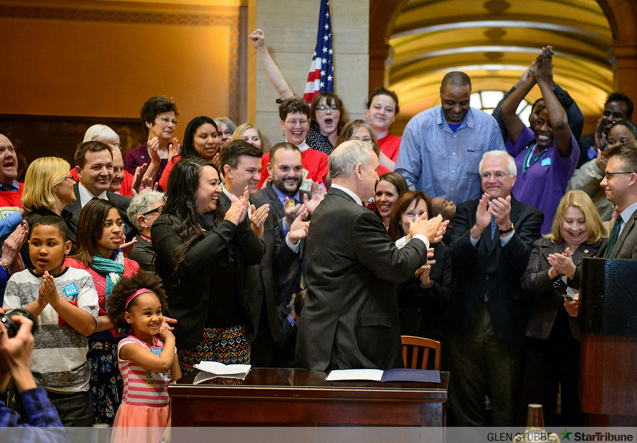 The Rotunda crowd cheered after Governor Mark Dayton signed the minimum wage bill into law at a public bill signing ceremony Monday the Minnesota State Capitol Rotunda.  The bill, which was passed by the Legislature last week, will increase Minnesota's minimum wage to $9.50 per hour, and index it to inflation.       ]   GLEN STUBBE * gstubbe@startribune.com   Monday, April 14, 2014