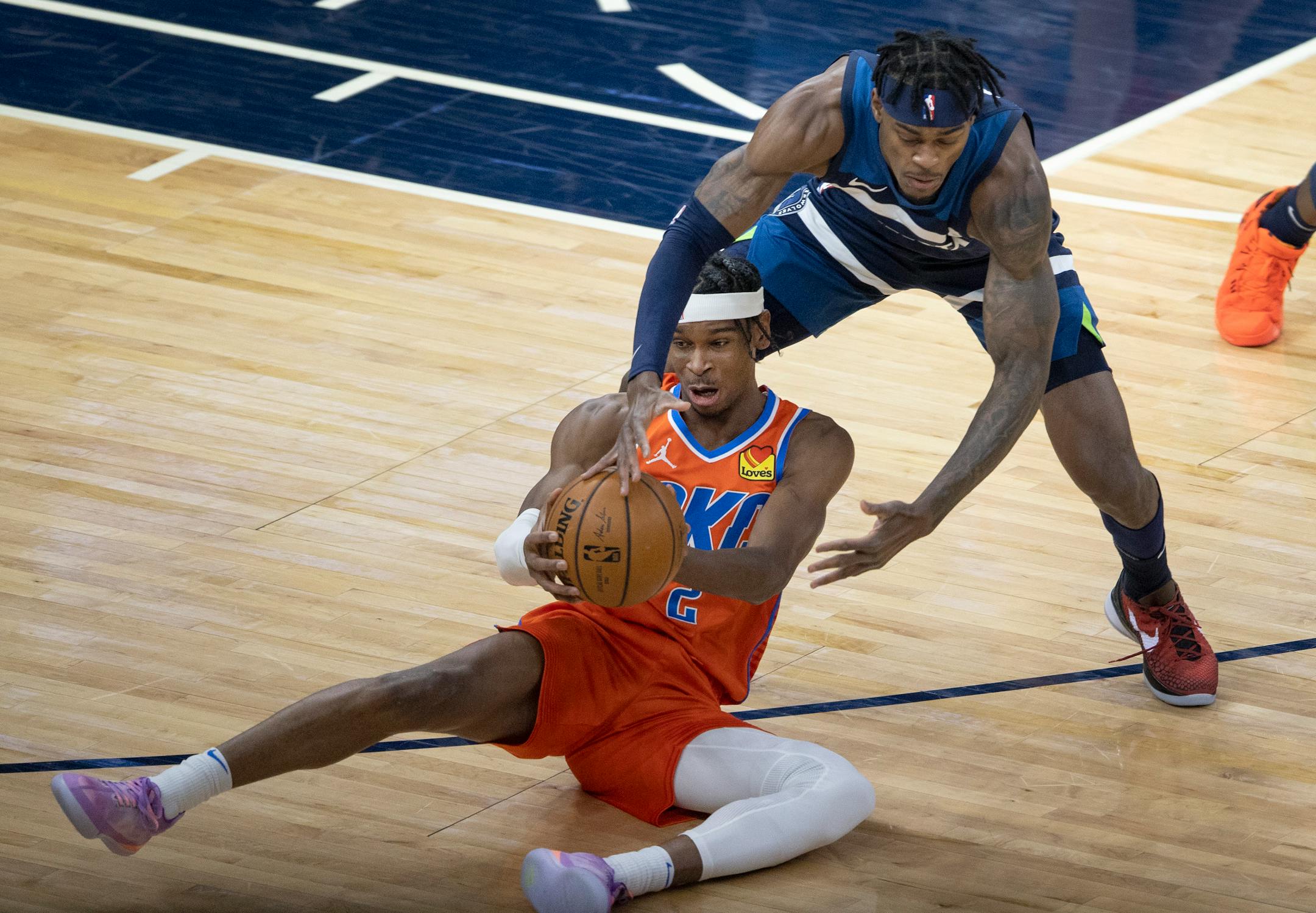 Shai Gilgeous Alexander (2) of the Oklahoma City Thunder and Jarred Vanderbilt (8) of the Minnesota Timberwolves fought for the ball in the first quarter.