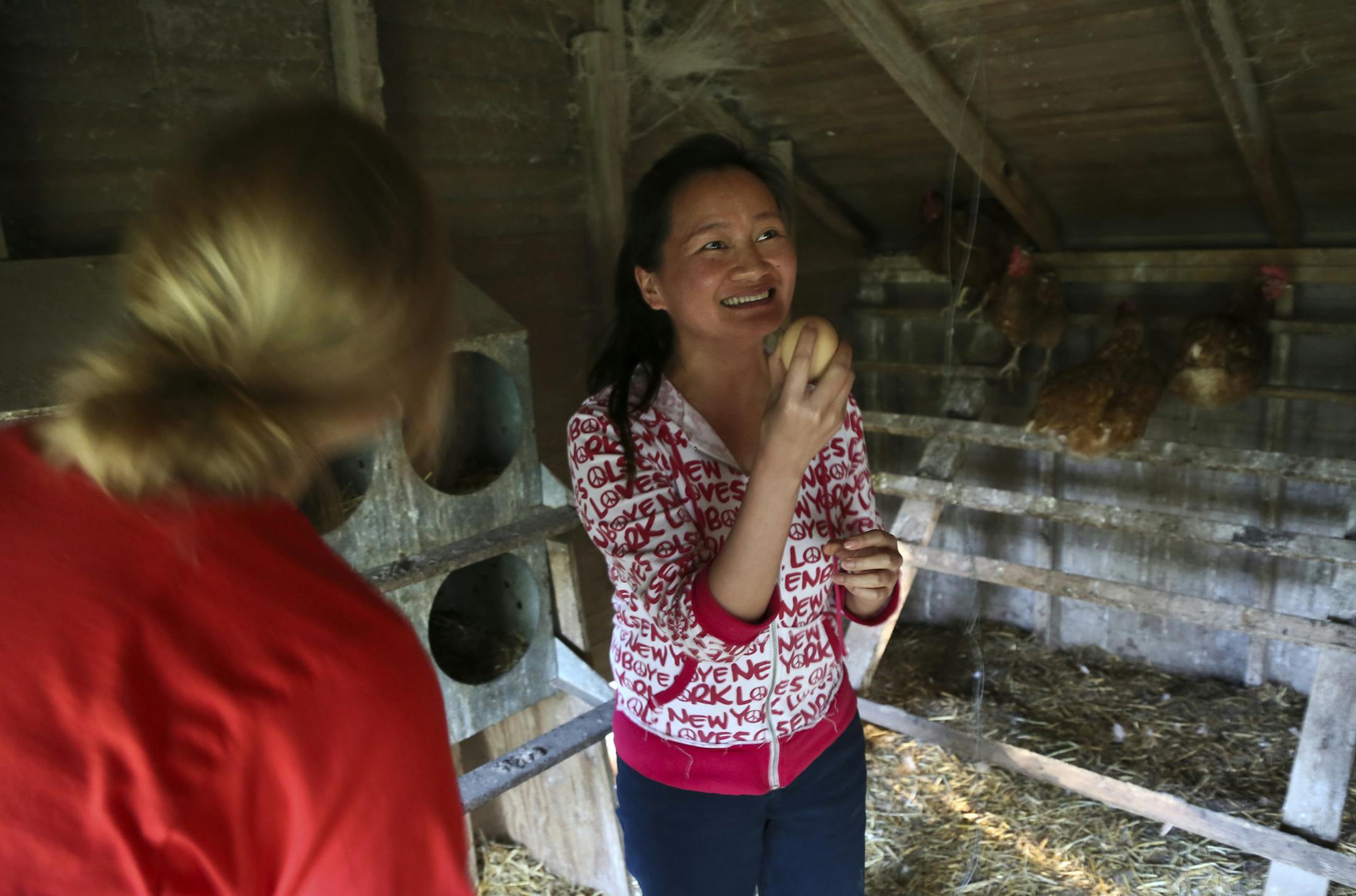 Chun Zhang, an international doctoral student at the University of Minnesota from China, is elated after plucking an egg from a hen in the hen house Sunday, June 2, 2013, in Windom, MN. Zhang was an apprentice instructor at the camp.](DAVID JOLES/STARTRIBUNE) djoles@startribune.com A University of Minnesota philosophy camp takes place each spring on the rolling prairie of southwestern Minnesota where students and instructors form a community for living and learning to investigate their own and o